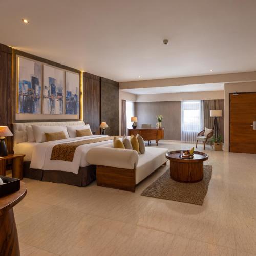 a large bedroom with two beds and a couch at Crystalkuta Hotel - Bali in Kuta