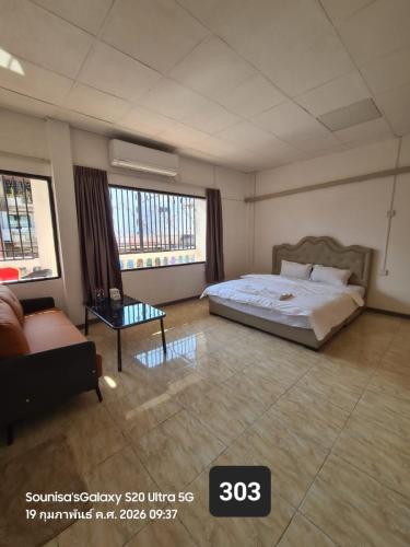 una camera da letto con un letto, un divano e finestre di The Loft Sihom a Vientiane