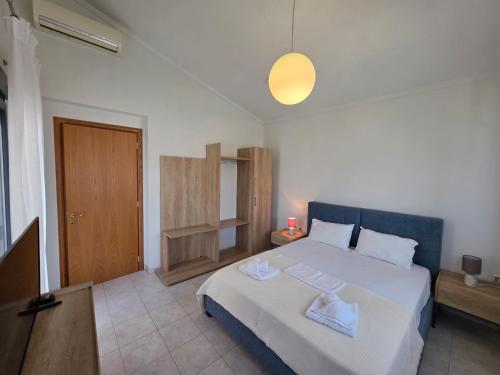 a bedroom with a large white bed and a light at Venetia Luxurious Villa in Iraklitsa