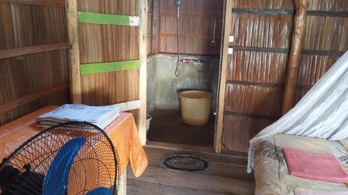 a small room with a bed and a room with a bucket at West Waigeo Bungalow in Kabu