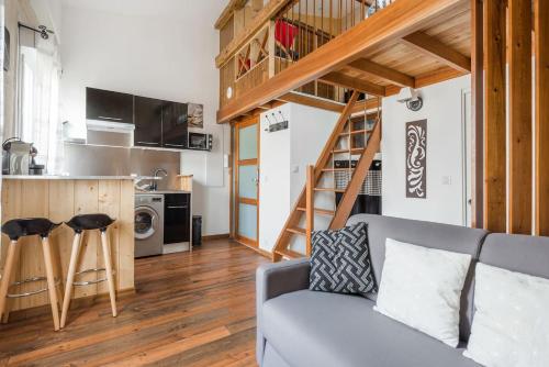 un salon avec un canapé et une cuisine dans l'établissement Le Malleret, Centre-ville, Parking gratuit, à Bordeaux