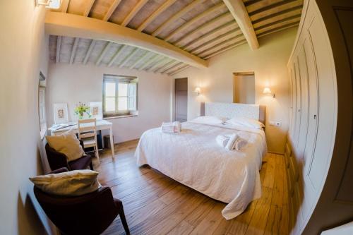 a bedroom with a bed and a desk in a room at Borgo Le Moraiole in Massa Marittima