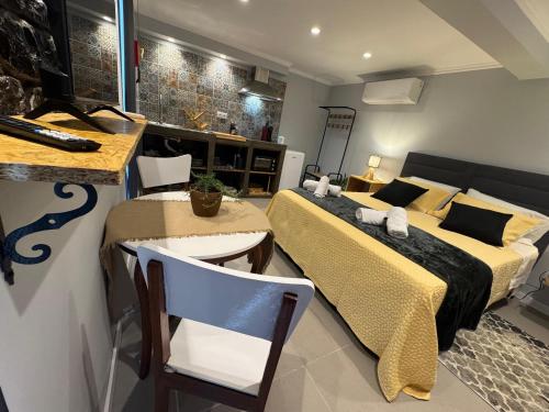 a bedroom with two beds and a table and chairs at Refúgio do Nevoeiro Estudio in Porto Moniz