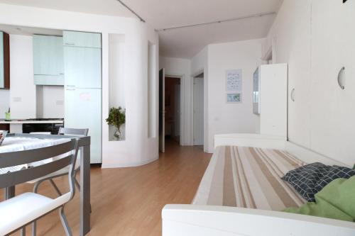 a kitchen and living room with white walls and wood floors at Holiday home Isola Rossa in Isola Rossa