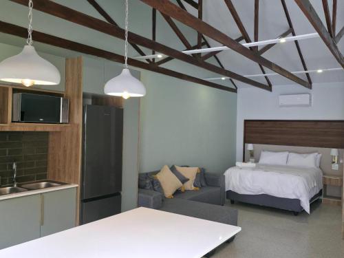 eine Küche und ein Schlafzimmer mit Bett und Sofa in der Unterkunft Leipoldt Self-Catering Accommodation in Secunda