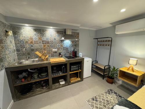 a kitchen with a sink and a counter at Refúgio do Nevoeiro Estudio in Porto Moniz