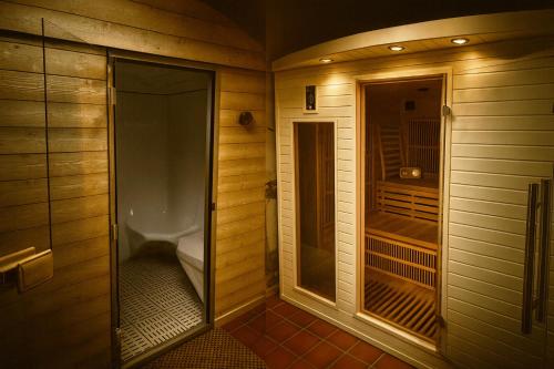 a walk in shower in a bathroom with wooden walls at SOLASI - Gîte et Chambres D'hôtes in Blanquefort-sur-Briolance