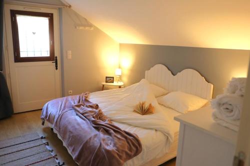 a bedroom with a white bed with a wooden headboard at Maison Mayjune Cottage in Irai