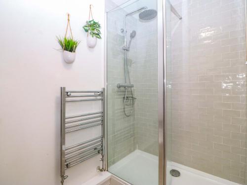 a shower in a bathroom with a glass shower stall at 27 Kingshead Street in Pwllheli