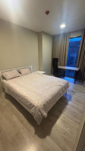 a bedroom with a bed and a desk and a window at quintara arte 52,on nut in Bangkok