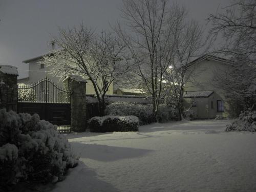 un patio cubierto de nieve con una casa y árboles en B&B Borgo San Vito, en Ronchi dei Legionari