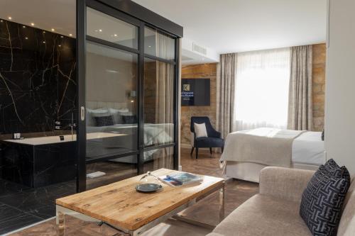 a hotel room with a bed and a table at Domaine de la Klauss & Spa, Restaurant Gastronomique Le K in Montenach