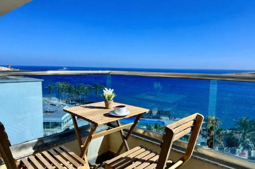 a table and chairs on a balcony with a view of the ocean at Sunrise Bay Apartments - Frontline Sea Views in St. Paul's Bay