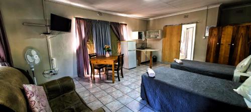 a room with a bed and a table and a desk at Marli Guesthouse Self-Catering in Welkom