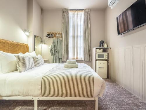 a bedroom with a large bed and a window at The Rokxy Townhouses & Residences - Kings Cross in London