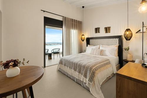 a bedroom with a bed and a desk and a table at Aether-Castle vista in Monemvasia