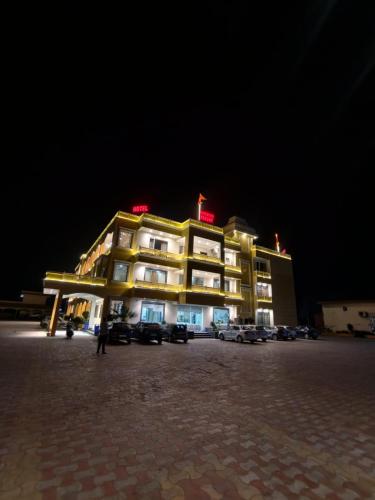 a building with cars parked in front of it at night at Narayan resort and restaurant in Aklera