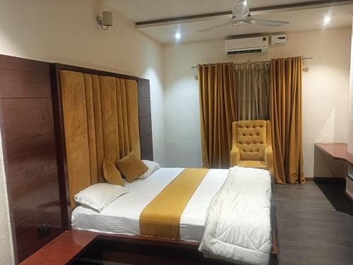 a bedroom with a large bed and a chair at Narayan resort and restaurant in Aklera