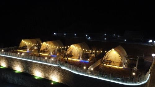 a row of tents at night with lights at The Hill Glamping in Yeoju