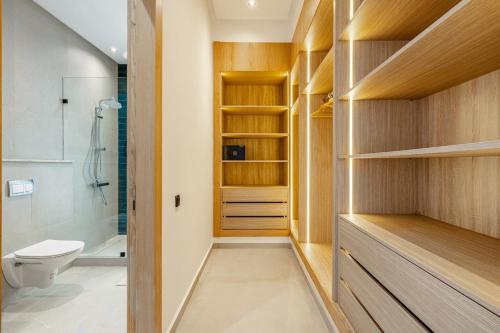 a bathroom with a toilet and a walk in shower at Citrus Bloom Manor Marrakech in Oulad Mazoug