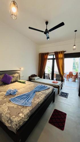 a bedroom with two beds and a ceiling fan at Saffron Swell Villa in Arugam Bay