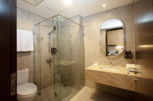 a bathroom with a shower and a toilet and a sink at Louis Kienne Hotel Cikarang in Cikarang