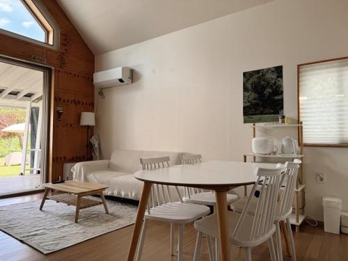 a living room with a table and chairs and a couch at Gapyeong Sol Stay Spa Pension in Gapyeong