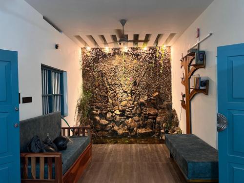a wall in a room with a couch in front of it at Kabani By Kallar in Trivandrum
