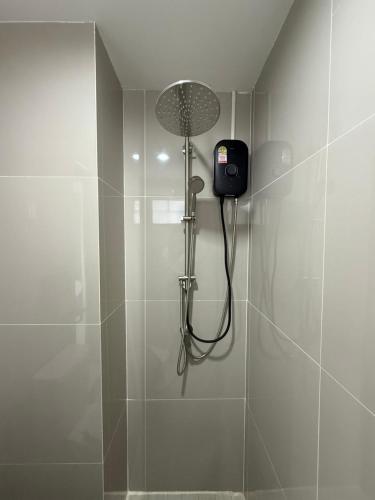 a bathroom with a shower with a phone on the wall at I am Daily Mansion in Ban Phan Sadet Nai