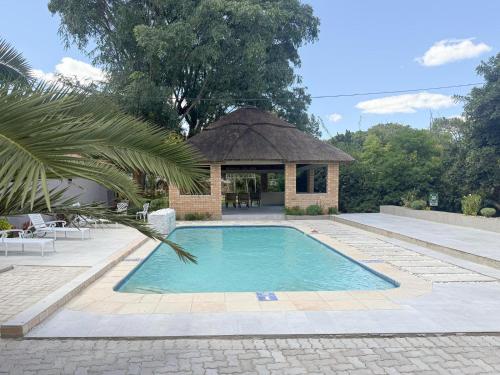 a swimming pool in front of a gazebo at Mevis Boutique Hotel in Bulawayo