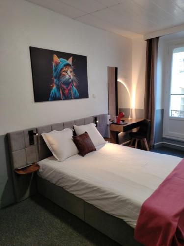 a bedroom with a bed with a painting of a cat on the wall at Hôtel Saint Daniel in Nantes