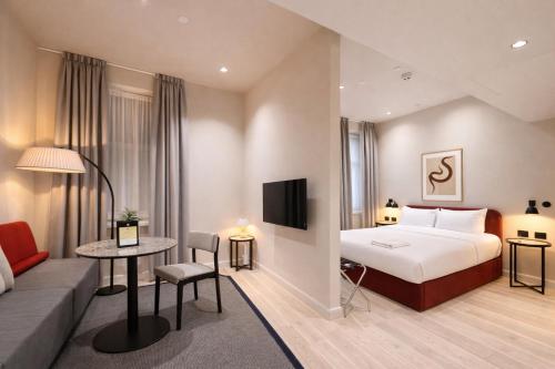 a hotel room with a bed and a couch at VCity Suites at The Teacher in Glasgow