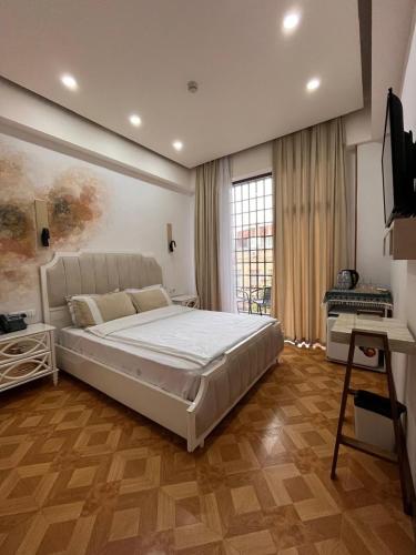 a bedroom with a large white bed and a television at LUXIN in Tbilisi City
