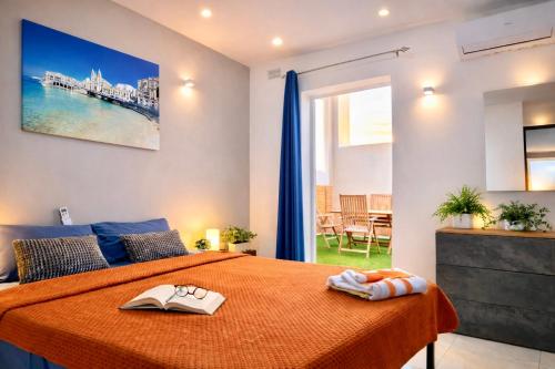 a bedroom with a bed with an orange bedspread at Sunrise Bay Apartments - Frontline Sea Views in St. Paul's Bay