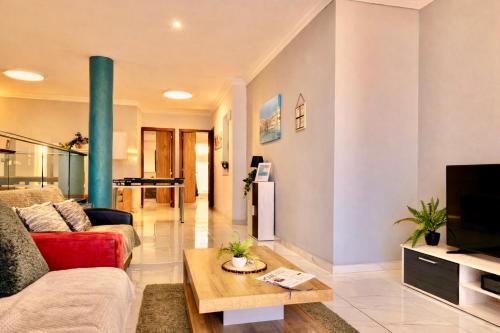 a living room with a couch and a table at Sunrise Bay Apartments - Frontline Sea Views in St. Paul's Bay