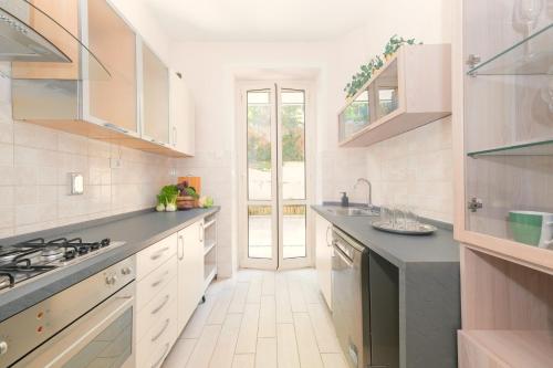 a kitchen with white cabinets and black counter tops at Luxury Vatican Home - Private Garden in Rome