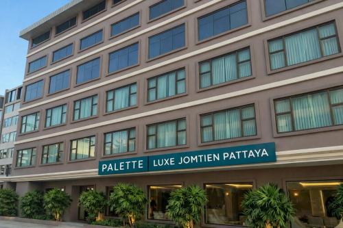 a building with a sign for a hotel at Palette Luxe Jomtien Beach Pattaya in Jomtien Beach
