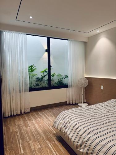 a bedroom with a bed and a large window at Ideal for your vacation! in Buôn Dhă Prŏng