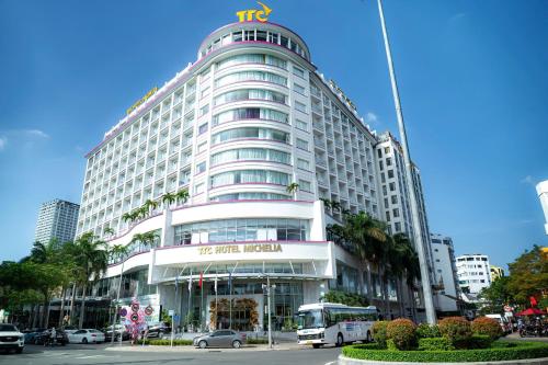 a tall white building with a tes hotel sign on it at TTC Hotel Michelia in Nha Trang