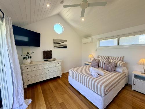 a bedroom with a bed and a dresser and a window at Shorebreak Port Campbell in Port Campbell