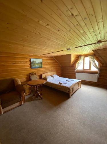 a bedroom with a bed and a table in a room at Три підкови in Mykulychyn