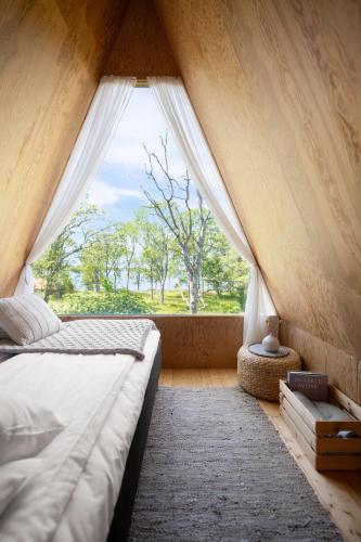 a bedroom with a bed with a large window at Lidö Värdshus in Lidö