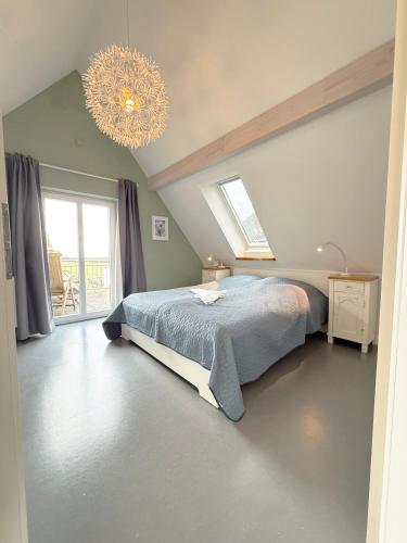 a bedroom with a bed and a chandelier at Haus Charlotte mit Meerblick in Fehmarn