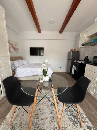 a bedroom with a bed and a glass table with two chairs at The Luxe Studio in Lusaka