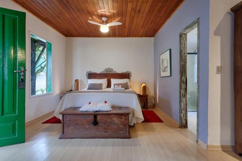 a bedroom with a bed with a wooden headboard at Pousada Carumbé Lavras Novas in Lavras Novas
