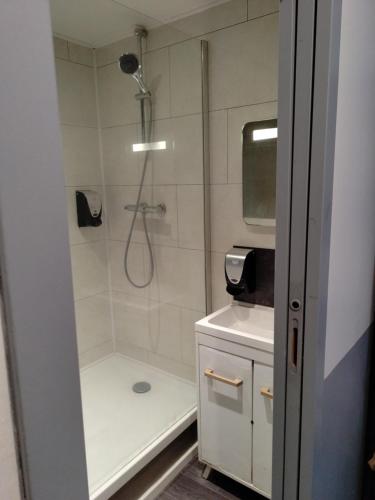 a bathroom with a shower with a toilet and a sink at Hôtel Saint Daniel in Nantes