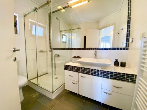 a bathroom with a sink and a glass shower at Nautica Villa in Hanioti