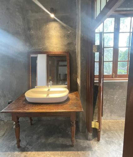 a bathroom with a sink on a wooden table at Weaver Bird Residencies in Hewagama