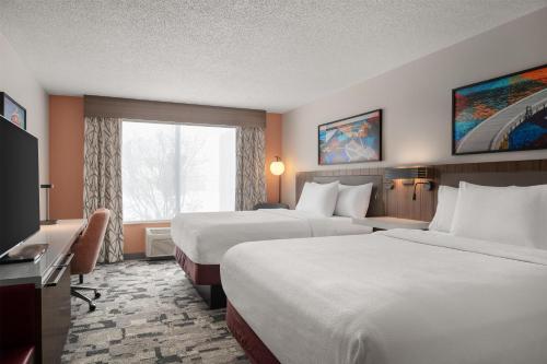 a hotel room with two beds and a window at Hilton Garden Inn Indianapolis/Carmel in Carmel