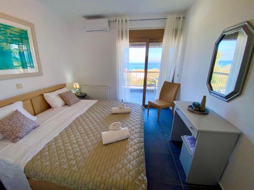 a bedroom with a bed with a desk and a window at Nautica Villa in Hanioti